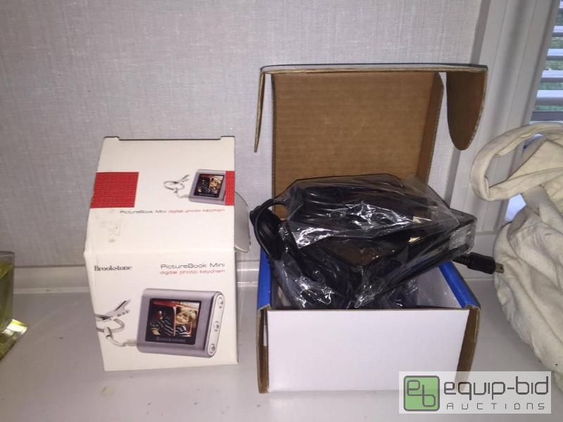lot 62 image: NEW Garmin Nuvi Chargers, Cases and Accesories in Box  Brookstone Picture Book Mini with Casein box