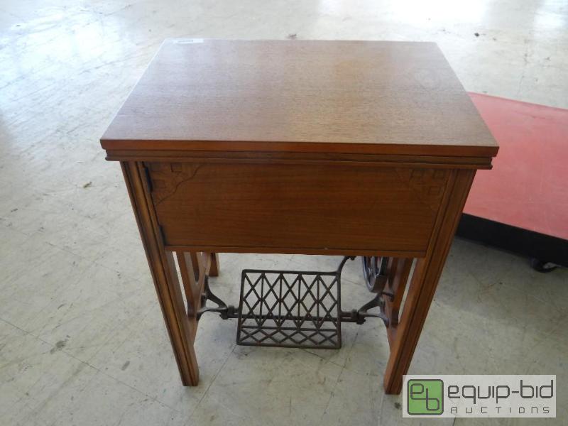 lot 561 image: Antique treadle sewing machine with cabinet. ...
